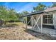 Backyard with gravel area and patio area covered by a pergola and string lights at 7309 N Huntley Ave, Tampa, FL 33604