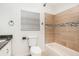 Bathroom showcasing a tiled bathtub and shower with a neutral color scheme and a window at 7309 N Huntley Ave, Tampa, FL 33604