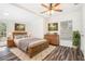 Cozy bedroom featuring a wooden bed frame, wood flooring, and bright natural light at 7309 N Huntley Ave, Tampa, FL 33604