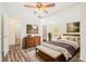 Comfortable main bedroom with wood flooring, garden view, and ensuite bath access at 7309 N Huntley Ave, Tampa, FL 33604