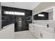 Luxury bathroom with double vanity, framed LED mirror, sleek black tile and marble floors, offering a spa-like experience at 7372 Madrid Rd, Weeki Wachee, FL 34613