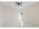 Bright bedroom with a ceiling fan, large window, and marble floors, creating a comfortable and airy living space at 7372 Madrid Rd, Weeki Wachee, FL 34613