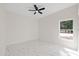 Bright bedroom with a ceiling fan, large window, and marble floors, creating a comfortable and airy living space at 7372 Madrid Rd, Weeki Wachee, FL 34613