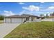 Beautiful single-story home featuring a three-car garage, modern design, and well-maintained landscaping at 7372 Madrid Rd, Weeki Wachee, FL 34613