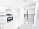 Updated kitchen featuring stainless steel appliances, granite countertops, and ample storage in white cabinets at 7740 Sagebrush Dr, Port Richey, FL 34668
