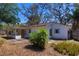 Charming one-story home featuring a cozy, covered porch, mature trees, and inviting landscaping at 7802 N 53Rd St, Tampa, FL 33617