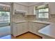 Well-lit kitchen featuring ample cabinet space, neutral countertops, and charming vintage design at 7802 N 53Rd St, Tampa, FL 33617