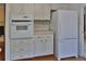 Kitchen featuring white appliances, mosaic tile backsplash, and wood flooring throughout at 7802 N 53Rd St, Tampa, FL 33617