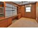 Home office featuring ceiling fan, built-in shelving, wooden desk and paneling at 7802 N 53Rd St, Tampa, FL 33617
