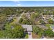 Aerial view showcasing the home's location within a neighborhood surrounded by mature trees, streets and other houses at 8195 Wooden Dr, Spring Hill, FL 34606