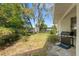 Spacious backyard with mature trees, lush greenery, and a patio area with a grill at 8195 Wooden Dr, Spring Hill, FL 34606