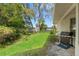 Lush backyard featuring green grass, mature trees, and a barbecue grill, creating an ideal outdoor space for relaxation at 8195 Wooden Dr, Spring Hill, FL 34606