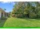 View of spacious backyard with green lawn and trees, highlighting the serene and private outdoor living space at 8195 Wooden Dr, Spring Hill, FL 34606