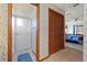Bathroom with a tiled shower, toilet, and wooden closet adjacent to the primary bedroom at 8195 Wooden Dr, Spring Hill, FL 34606