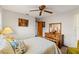 Bedroom with ceiling fan, floral comforter, wooden furniture including dresser and mirror, and neutral walls at 8195 Wooden Dr, Spring Hill, FL 34606