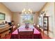 Formal dining room with traditional chandelier, wooden furniture, and natural light from the window at 8195 Wooden Dr, Spring Hill, FL 34606