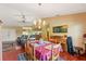Bright dining room showcasing wood floors, traditional furniture, chandelier, and open access to the kitchen at 8195 Wooden Dr, Spring Hill, FL 34606