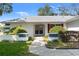 Inviting entrance with a paved walkway leading to double front doors and lush landscaping at 8195 Wooden Dr, Spring Hill, FL 34606