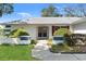 Inviting entrance with a paved walkway leading to double front doors and lush landscaping at 8195 Wooden Dr, Spring Hill, FL 34606