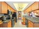 Well-lit kitchen with wooden cabinets, granite countertops, stainless steel appliances, and tile flooring at 8195 Wooden Dr, Spring Hill, FL 34606