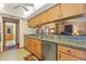 Galley kitchen with wooden cabinets, granite countertops, stainless steel appliances, and an open view to the living area at 8195 Wooden Dr, Spring Hill, FL 34606