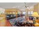 Spacious living room featuring hardwood floors, ceiling fans, and a glimpse into the open-concept kitchen at 8195 Wooden Dr, Spring Hill, FL 34606