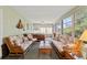 Sunroom with floral couches, ceiling fan, multiple windows and a hot tub at 8195 Wooden Dr, Spring Hill, FL 34606