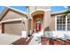 Home's front entrance showing a red front door and a landscaped yard at 8603 Sandy Plains Dr, Riverview, FL 33578