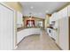 Open kitchen with white cabinets, appliances, tile flooring, and convenient bar seating area at 8603 Sandy Plains Dr, Riverview, FL 33578