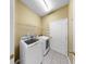 Bright laundry room with washer, dryer, wire shelving, and tiled floor at 8603 Sandy Plains Dr, Riverview, FL 33578