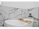 Luxurious white soaking tub with stylish marble accents and a wooden tray for ultimate relaxation at 102 Adriatic Ave, Tampa, FL 33606