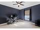 Well-lit bedroom with dark blue walls, a large monitor, and comfortable ergonomic seating area at 102 Adriatic Ave, Tampa, FL 33606