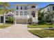 Stunning two-story home with a brick driveway, manicured lawn, and grand staircase entry at 102 Adriatic Ave, Tampa, FL 33606