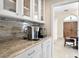 Kitchen countertop with granite, cabinets with glass door, coffee maker, and hallway at 102 Adriatic Ave, Tampa, FL 33606