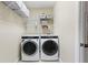 Laundry room featuring a modern washer and dryer set with convenient storage shelves at 102 Adriatic Ave, Tampa, FL 33606