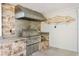 Outdoor kitchen featuring a built-in grill, stone accents, and ample counter space at 102 Adriatic Ave, Tampa, FL 33606