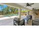Inviting covered patio with ceiling fans overlooking a pool, spa, and outdoor kitchen at 102 Adriatic Ave, Tampa, FL 33606