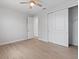 Bedroom with a ceiling fan, wood-look tile flooring, closet with sliding doors, and a doorway to another room at 10493 Grail Ave, Englewood, FL 34224