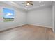 Light-filled bedroom with wood-look tile flooring and a ceiling fan at 10493 Grail Ave, Englewood, FL 34224