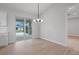 Bright dining area featuring a modern chandelier and sliding glass doors leading to a patio at 10493 Grail Ave, Englewood, FL 34224
