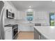 Well-equipped kitchen with stainless steel appliances, white cabinets and light countertops at 10493 Grail Ave, Englewood, FL 34224