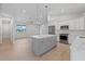 Bright kitchen with a gray island, stainless steel appliances, and white cabinets offers a modern feel at 10493 Grail Ave, Englewood, FL 34224