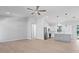 Bright, open-concept living room with recessed lighting and kitchen view with stainless steel appliances at 10493 Grail Ave, Englewood, FL 34224