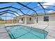 Backyard pool and patio surrounded by a screened-in enclosure, perfect for outdoor relaxation at 10493 Grail Ave, Englewood, FL 34224