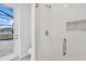 Shower featuring tiled walls, a glass enclosure, and a view of the backyard with a pool at 10493 Grail Ave, Englewood, FL 34224