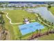 Aerial shot of a basketball court and park by a lake in a residential community at 10816 Wendover Dr, Palmetto, FL 34221