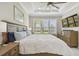 Well-lit bedroom with plantation shutters, tv, decorative ceiling, and hard surface floors at 10816 Wendover Dr, Palmetto, FL 34221