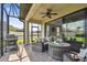 Comfortable screened patio featuring stone flooring, ceiling fan, and sliding glass doors to the home interior at 10816 Wendover Dr, Palmetto, FL 34221