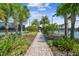 Scenic pathway leads to the community's well-kept tennis courts, surrounded by lush landscaping and mature palms at 10816 Wendover Dr, Palmetto, FL 34221