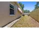 Side view of backyard and back of house, showing some grass, a fence, and AC unit at 1108 16Th Nw Ave, Clearwater, FL 33756